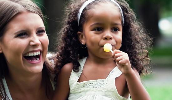 Woman holding child and laughing.